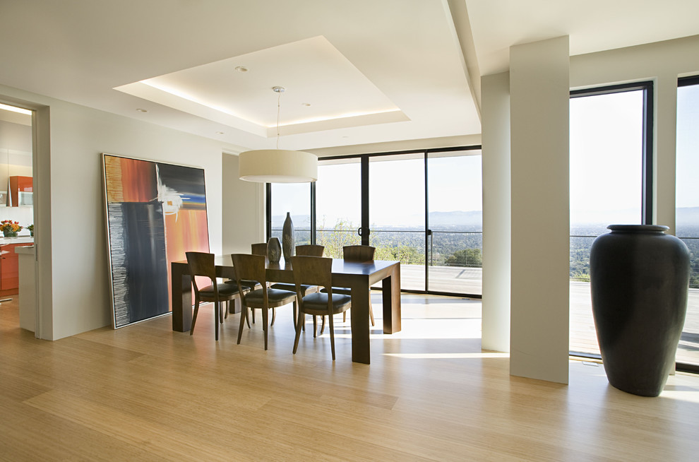 Esempio di una sala da pranzo aperta verso il soggiorno minimal con pavimento in bambù