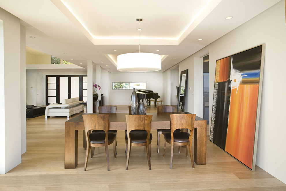 Immagine di una sala da pranzo aperta verso il soggiorno design con pavimento in bambù