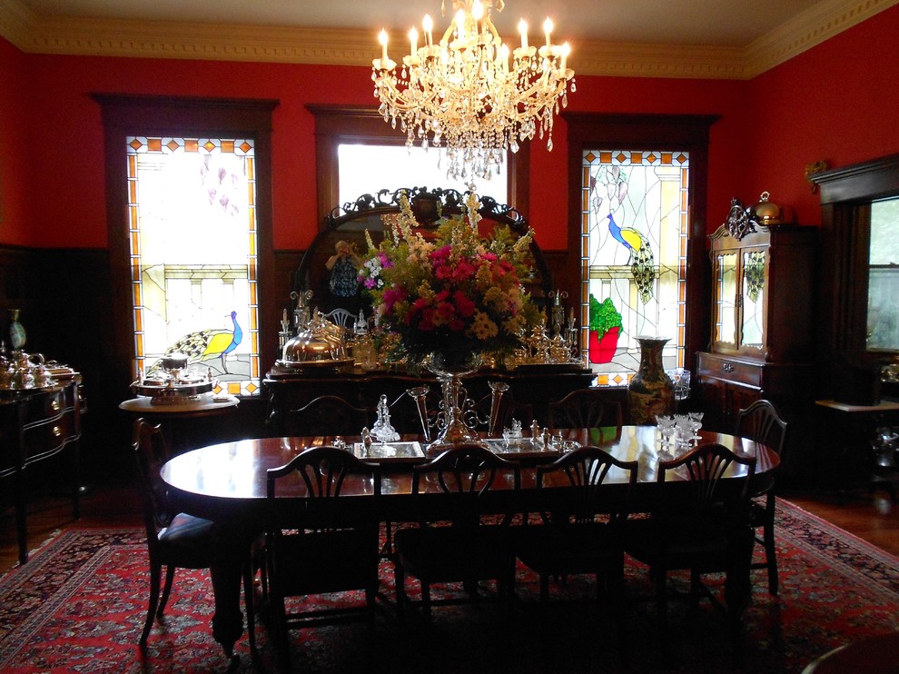 На фото: огромная кухня-столовая в классическом стиле с красными стенами, паркетным полом среднего тона и коричневым полом без камина с