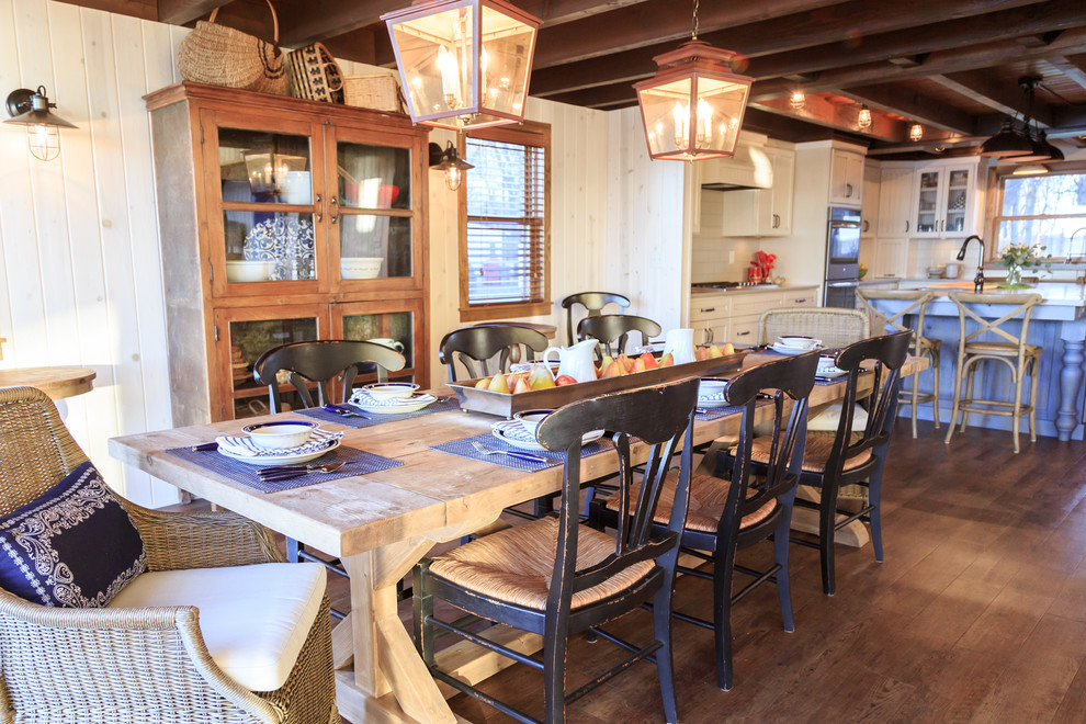 Cette image montre une grande salle à manger ouverte sur la cuisine chalet avec un sol en vinyl et un sol marron.