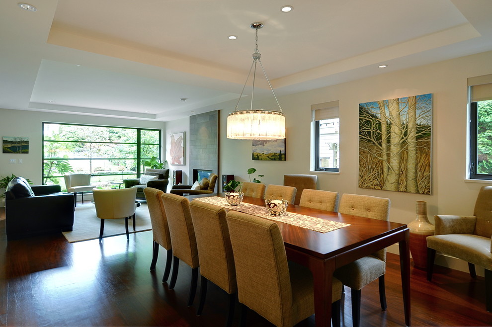 Inspiration pour une salle à manger ouverte sur le salon design de taille moyenne avec un mur beige et un sol en bois brun.