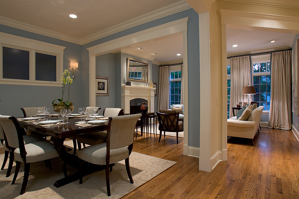 Inspiration pour une salle à manger ouverte sur le salon traditionnelle avec un mur bleu et un sol marron.