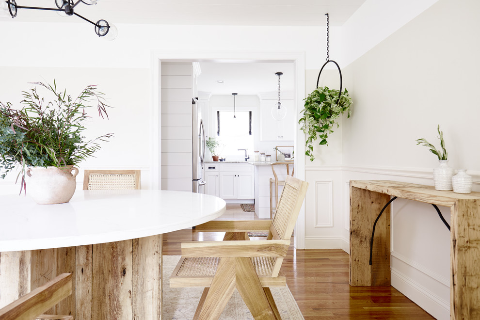 Idee per una sala da pranzo moderna chiusa e di medie dimensioni con pareti bianche, pavimento in legno massello medio e pavimento marrone