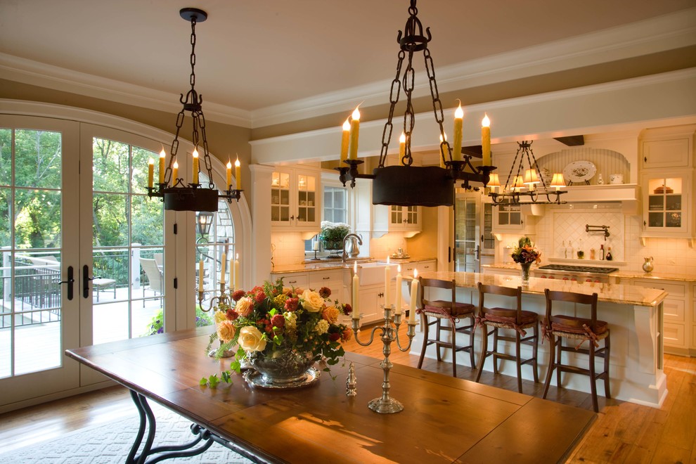 Cette image montre une salle à manger ouverte sur la cuisine traditionnelle avec un sol en bois brun et un sol marron.