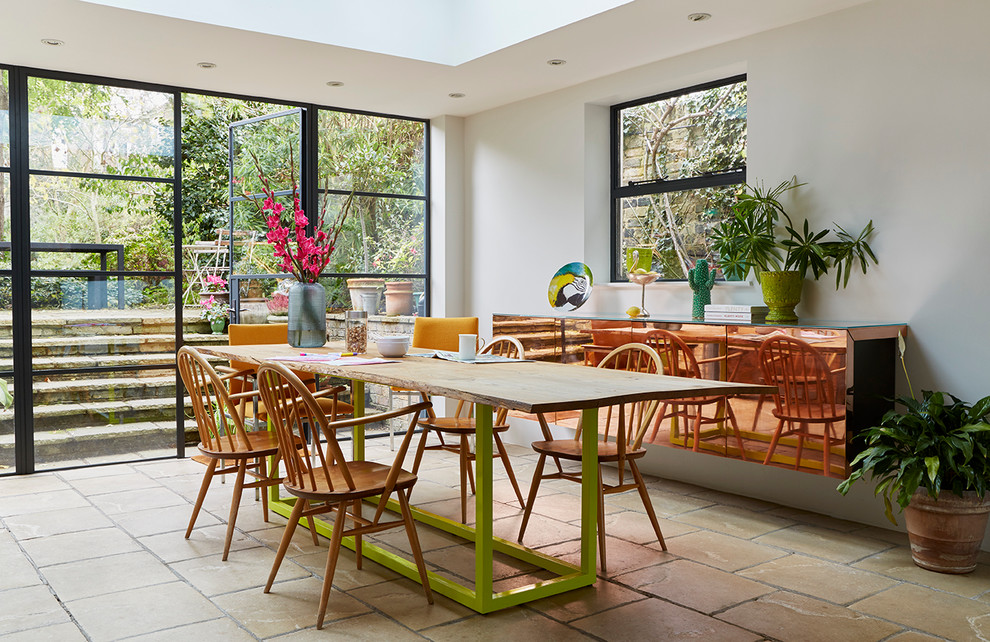 Large contemporary open plan dining room in London with white walls and concrete flooring.