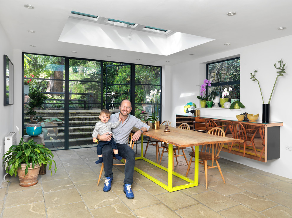 Idee per una grande sala da pranzo aperta verso la cucina minimal con pareti bianche e pavimento in cemento