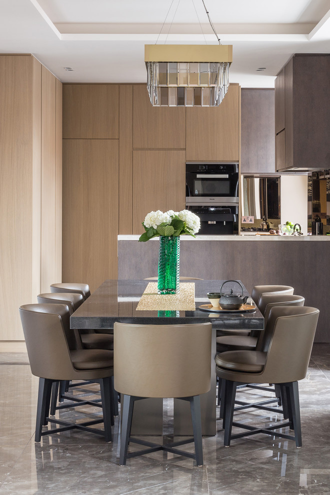 Cette photo montre une salle à manger ouverte sur la cuisine tendance de taille moyenne avec un mur marron et un sol en marbre.