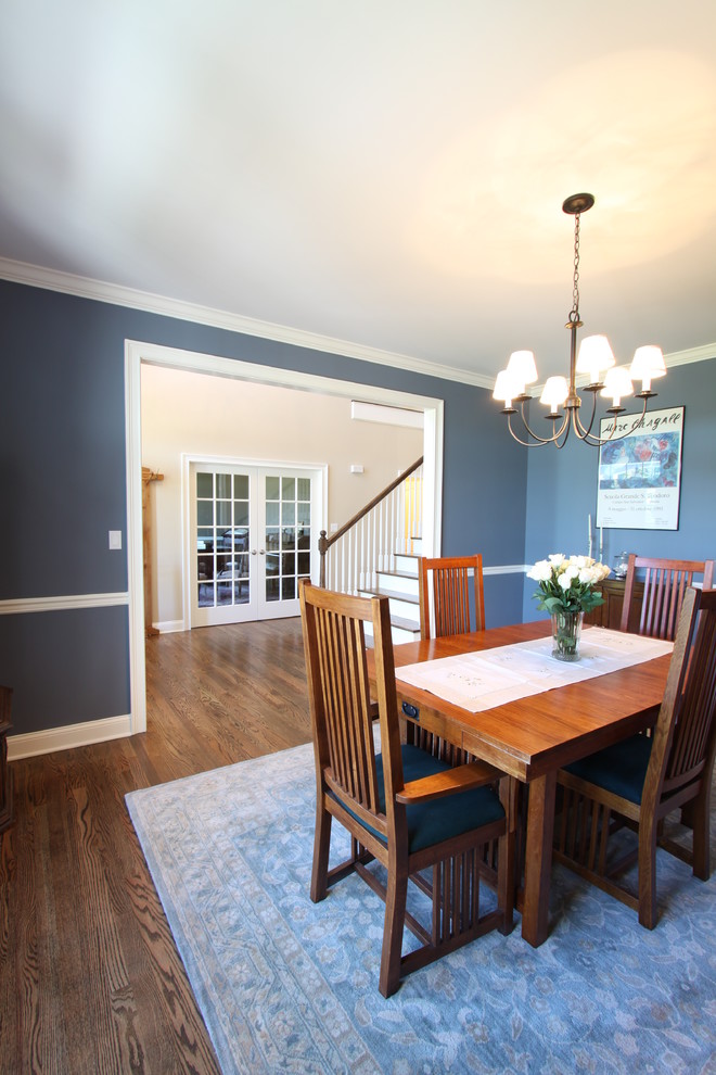 Idée de décoration pour une salle à manger tradition fermée avec un mur bleu et un sol en bois brun.