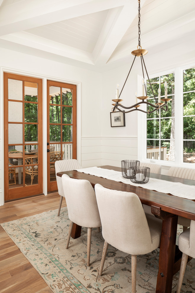 Inspiration for a large classic dining room in Charlotte with medium hardwood flooring, yellow walls and brown floors.