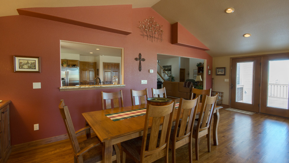 Idee per una sala da pranzo aperta verso il soggiorno tradizionale di medie dimensioni con pareti marroni e pavimento in legno massello medio