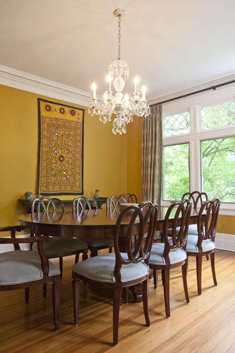 Diseño de comedor bohemio cerrado con paredes amarillas y suelo de madera clara
