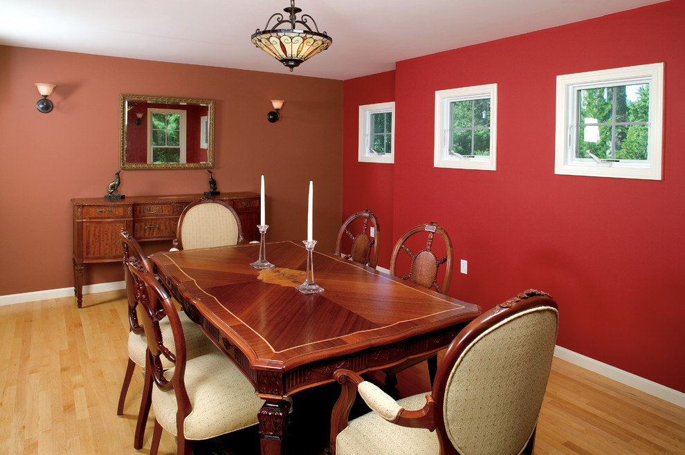 Foto di una sala da pranzo aperta verso la cucina chic di medie dimensioni con pareti rosse, parquet chiaro e nessun camino