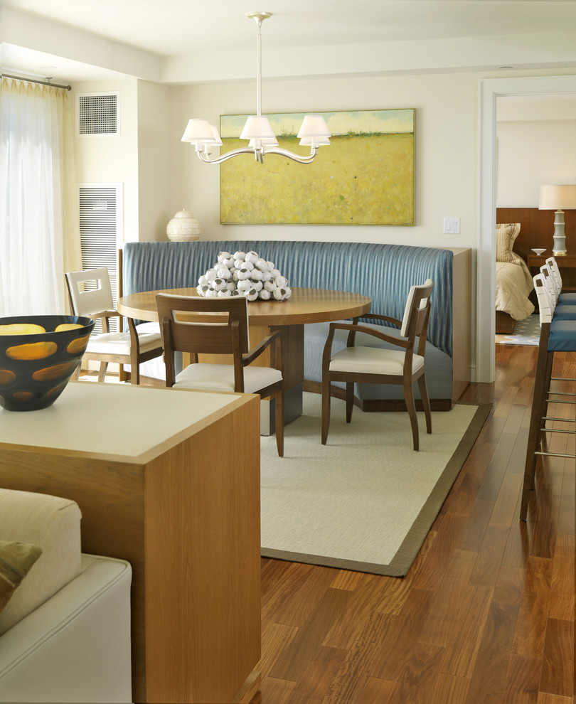 Ispirazione per una sala da pranzo aperta verso il soggiorno minimalista con pareti beige e pavimento in legno massello medio