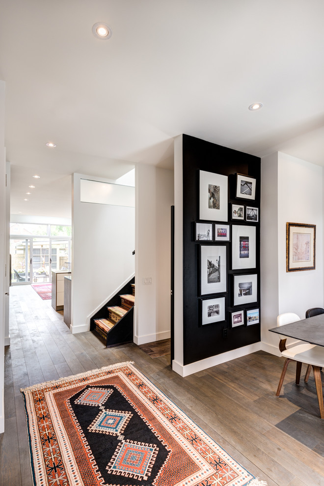 Geschlossenes, Kleines Modernes Esszimmer ohne Kamin mit schwarzer Wandfarbe und braunem Holzboden in Toronto