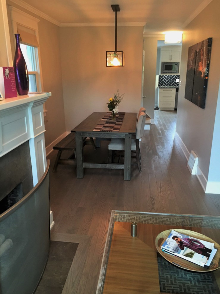 Photo of a medium sized contemporary enclosed dining room in Calgary with grey walls, a standard fireplace, a plastered fireplace surround, medium hardwood flooring and brown floors.
