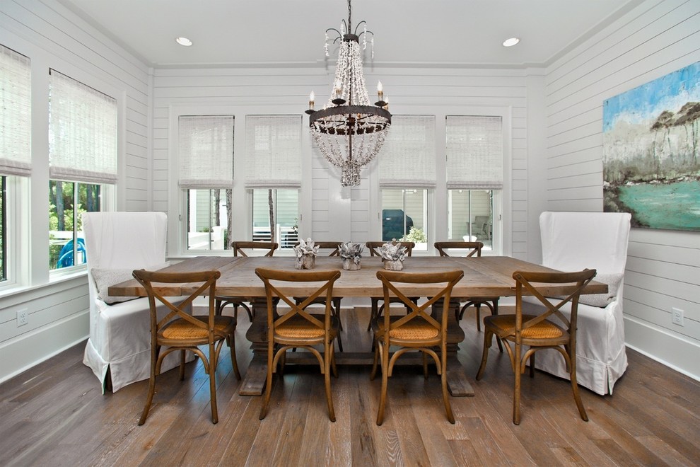Inspiration pour une salle à manger marine avec un mur blanc et un sol en bois brun.