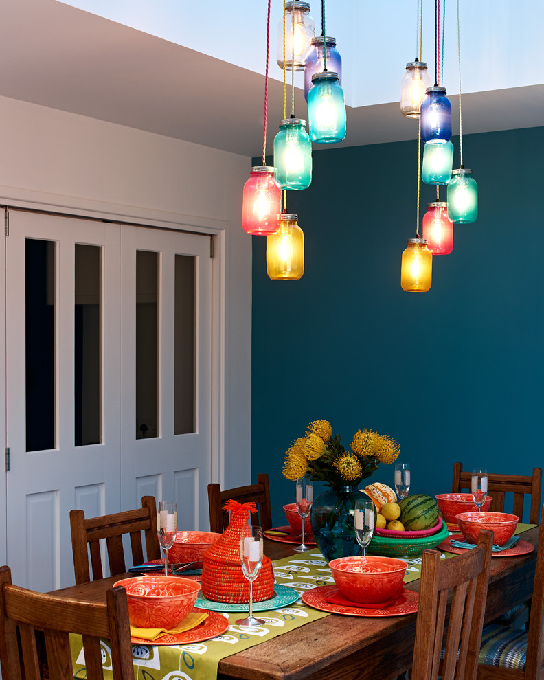 Immagine di una grande sala da pranzo aperta verso la cucina minimal con pareti blu e nessun camino