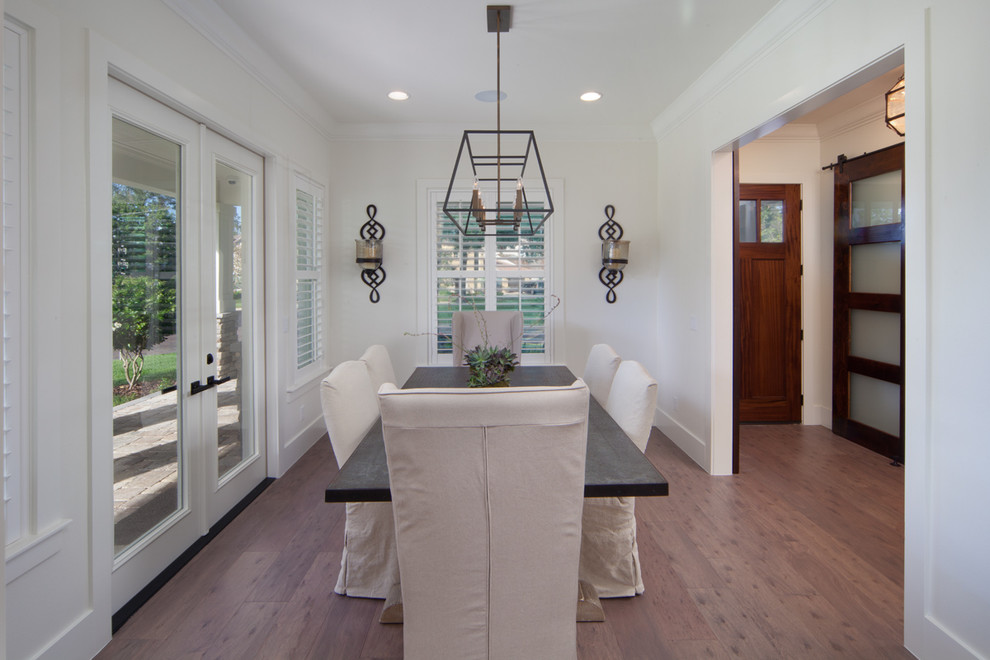 Inspiration for a medium sized traditional enclosed dining room in Orlando with white walls and medium hardwood flooring.