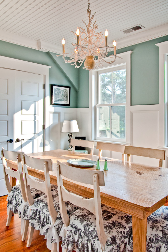 Exemple d'une salle à manger nature fermée avec un mur bleu, parquet foncé et éclairage.