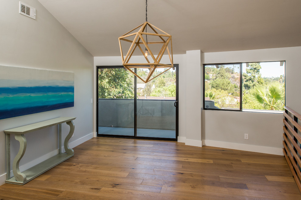 Offenes Modernes Esszimmer mit weißer Wandfarbe und braunem Holzboden in San Diego