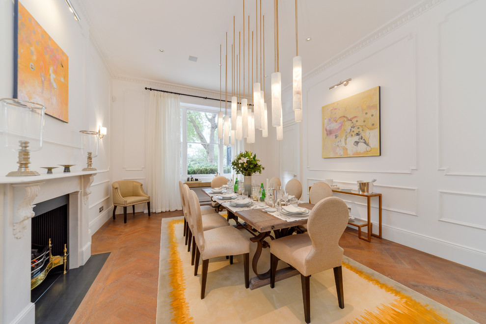 Idee per una sala da pranzo classica chiusa con pareti bianche, pavimento in legno massello medio, camino classico e pavimento marrone