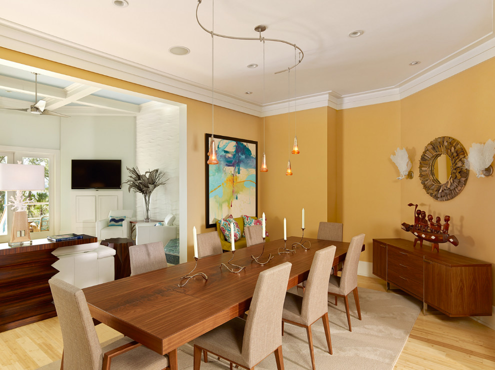Ispirazione per una sala da pranzo minimalista chiusa e di medie dimensioni con pareti gialle, parquet chiaro, nessun camino e pavimento marrone