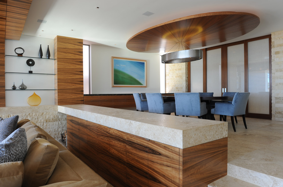 Immagine di una grande sala da pranzo aperta verso il soggiorno minimal con pareti beige e pavimento in pietra calcarea