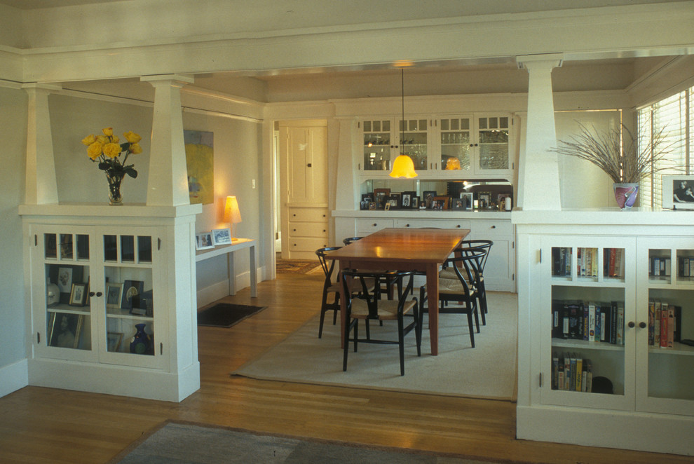 Immagine di una sala da pranzo aperta verso il soggiorno stile americano di medie dimensioni con pareti bianche, pavimento in legno massello medio e nessun camino
