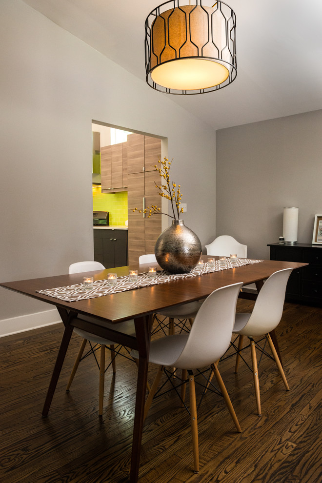 This is an example of a medium sized contemporary enclosed dining room in Philadelphia with grey walls, dark hardwood flooring, a two-sided fireplace, a tiled fireplace surround and brown floors.