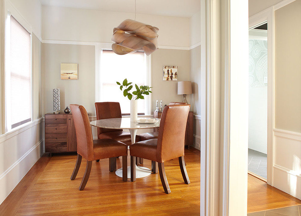 Immagine di una sala da pranzo design chiusa con pareti beige e pavimento in legno massello medio