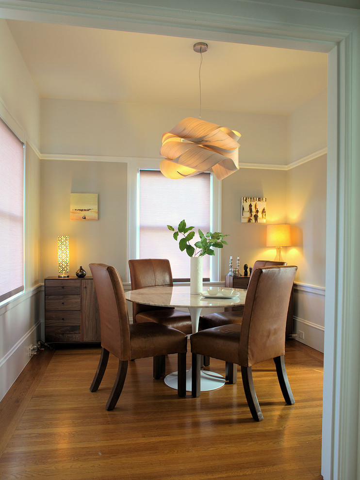 Ispirazione per una piccola sala da pranzo contemporanea chiusa con pareti beige e pavimento in legno massello medio