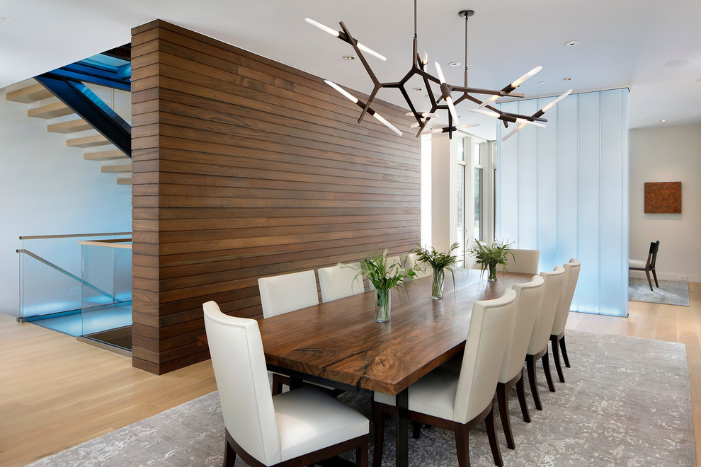 Foto di una sala da pranzo aperta verso il soggiorno minimal con pareti beige e parquet chiaro