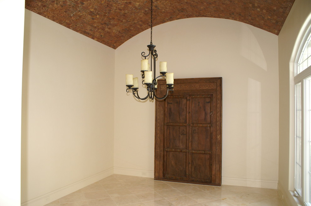 Imagen de comedor mediterráneo grande cerrado sin chimenea con paredes beige y suelo de piedra caliza