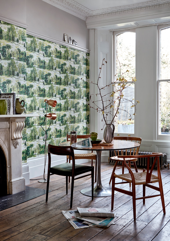 Réalisation d'une salle à manger nordique avec un mur vert, parquet foncé, une cheminée standard, un manteau de cheminée en pierre et éclairage.
