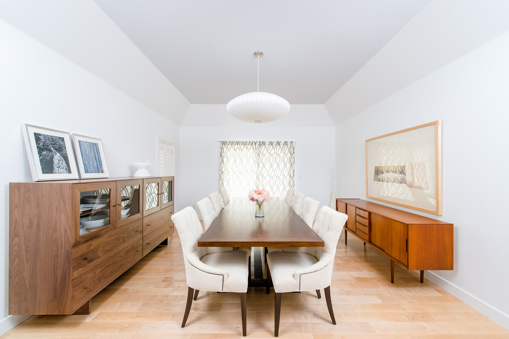 Large contemporary enclosed dining room in Orange County with white walls, light hardwood flooring and no fireplace.
