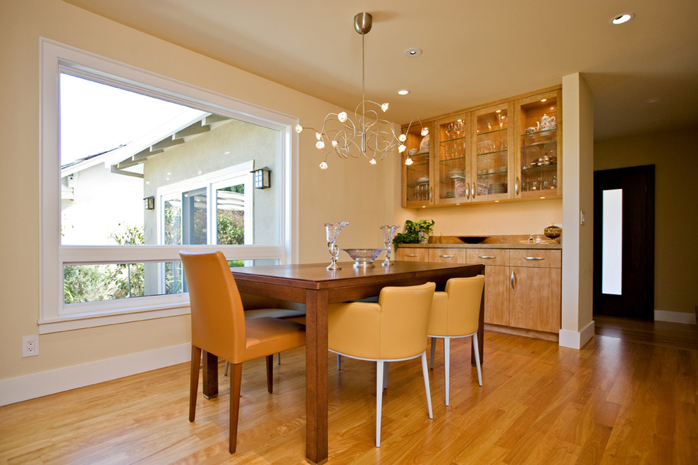 Aménagement d'une salle à manger moderne fermée et de taille moyenne avec un mur beige, un sol en bois brun et aucune cheminée.