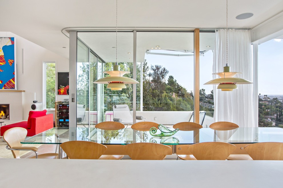 This is an example of a large modern open plan dining room in Los Angeles with beige walls and travertine flooring.