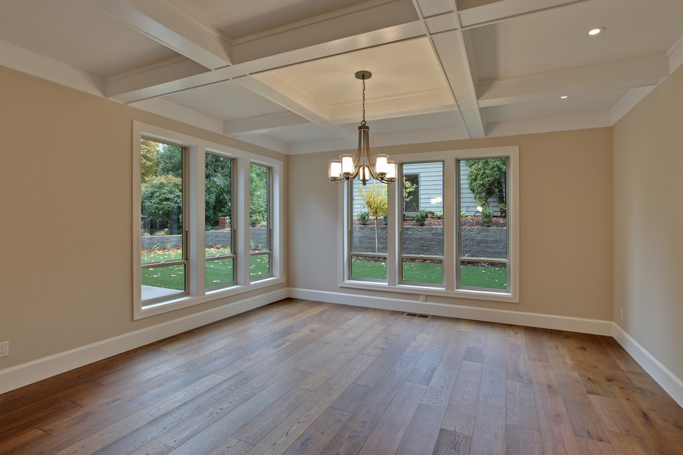 Immagine di una grande sala da pranzo aperta verso la cucina design con pareti beige e pavimento in legno massello medio
