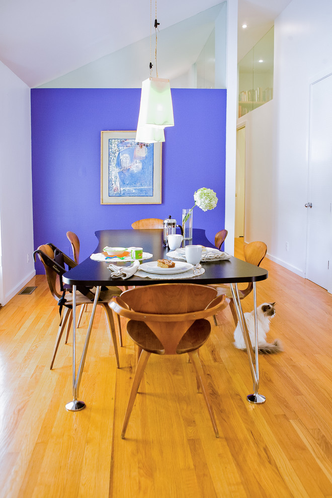 Modelo de comedor moderno pequeño abierto con paredes púrpuras y suelo de madera clara