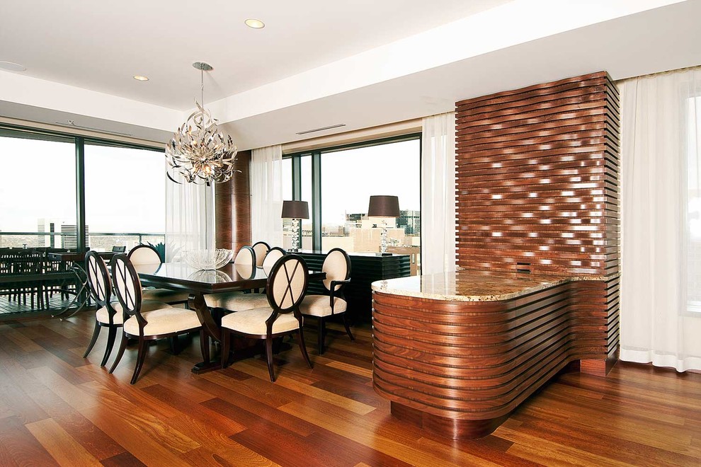 Cette image montre une salle à manger ouverte sur la cuisine minimaliste de taille moyenne avec un mur blanc, un sol en bois brun et aucune cheminée.
