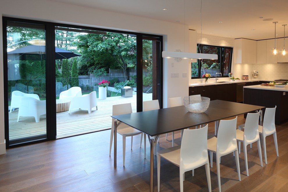 Immagine di una sala da pranzo aperta verso la cucina moderna di medie dimensioni con pareti bianche e parquet chiaro
