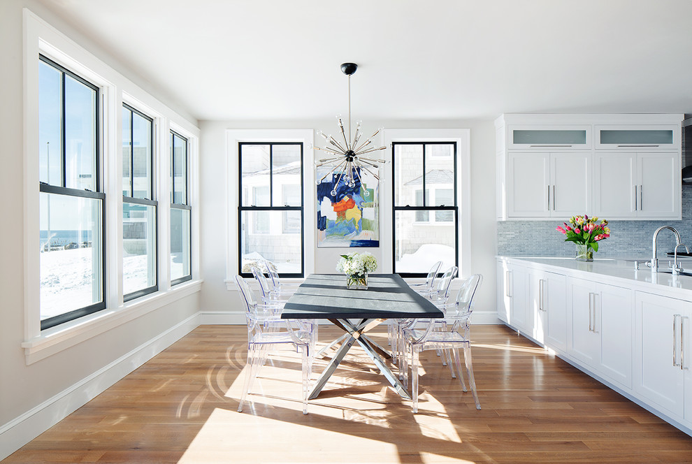 На фото: кухня-столовая в стиле неоклассика (современная классика) с белыми стенами и паркетным полом среднего тона с