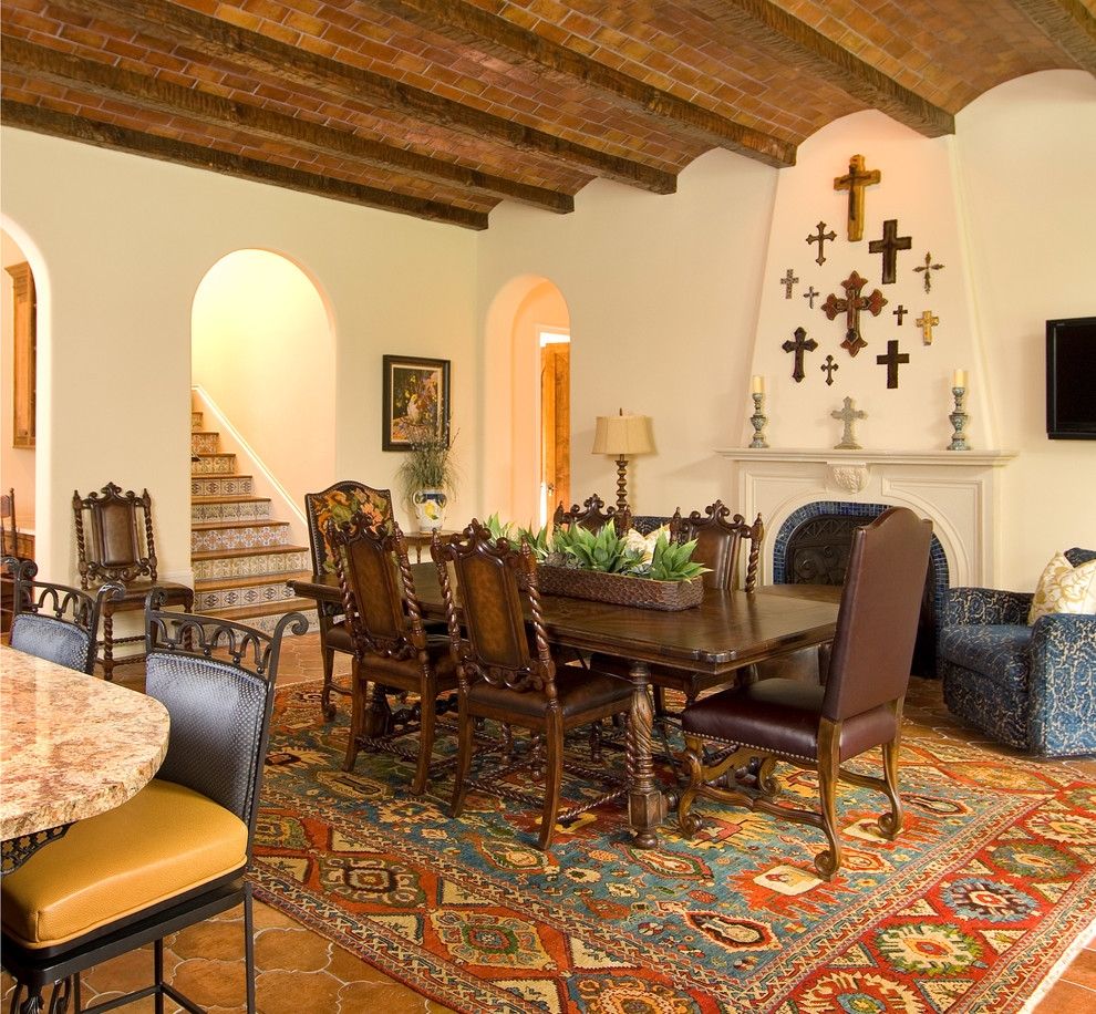 Foto de comedor de cocina mediterráneo con paredes beige, todas las chimeneas y marco de chimenea de baldosas y/o azulejos