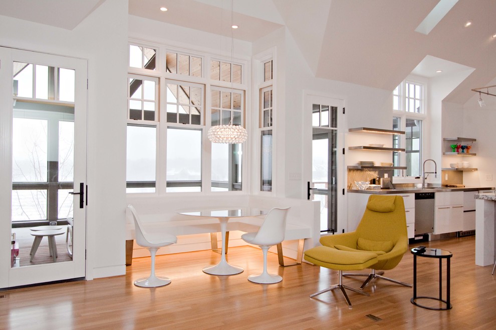 Ispirazione per una sala da pranzo aperta verso il soggiorno minimal di medie dimensioni con pareti bianche, pavimento in legno massello medio e nessun camino