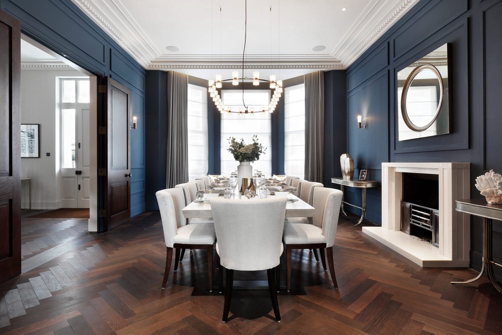 Classic enclosed dining room in London with blue walls, dark hardwood flooring, a standard fireplace and brown floors.
