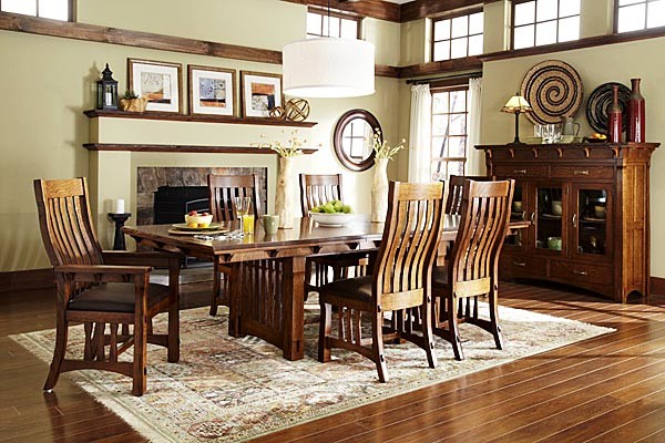 Cette image montre une salle à manger ouverte sur le salon traditionnelle de taille moyenne avec un mur beige, un sol en bois brun, une cheminée standard, un manteau de cheminée en pierre et un sol marron.