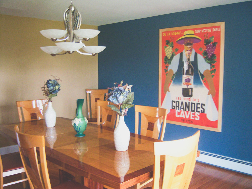 Exemple d'une grande salle à manger tendance fermée avec un mur bleu et un sol en bois brun.