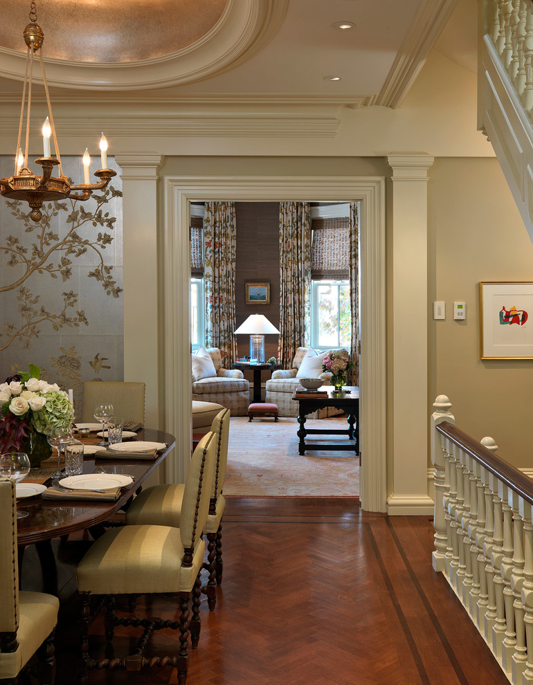Cette image montre une salle à manger traditionnelle avec un mur beige, parquet foncé et éclairage.