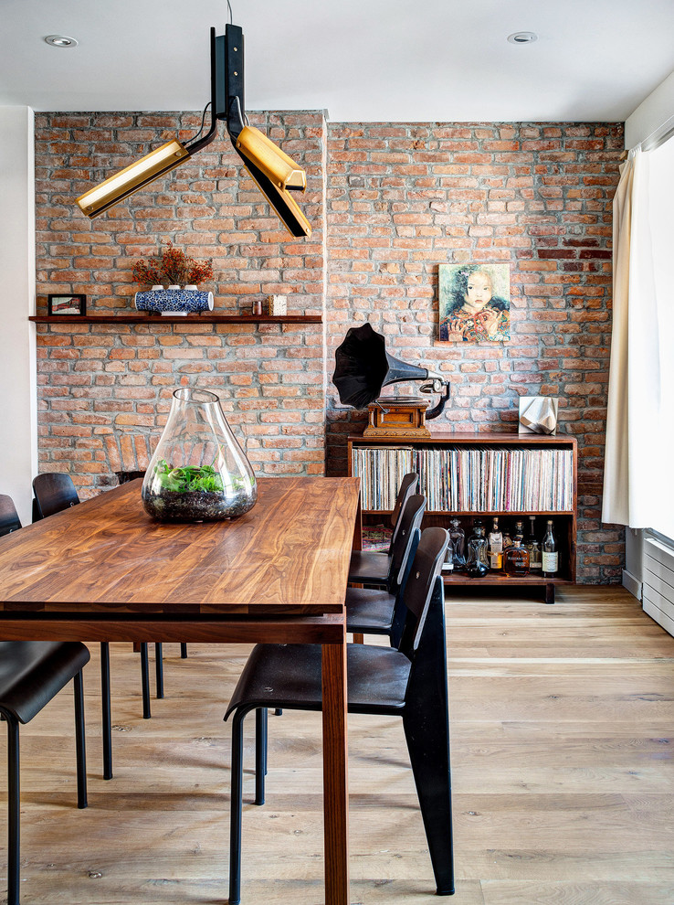 Inspiration for an urban dining room in Montreal with red walls and light hardwood flooring.