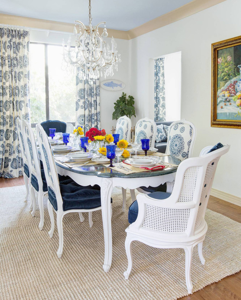 Example of a beach style medium tone wood floor dining room design in Los Angeles with white walls